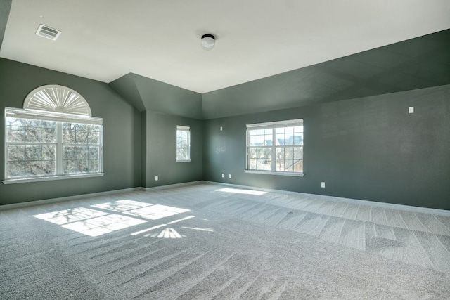 spare room with carpet flooring, baseboards, and vaulted ceiling