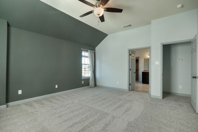 unfurnished bedroom with light carpet, vaulted ceiling, baseboards, and a ceiling fan