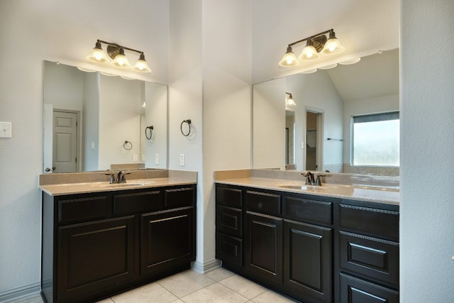 full bath featuring tile patterned floors, two vanities, and vaulted ceiling