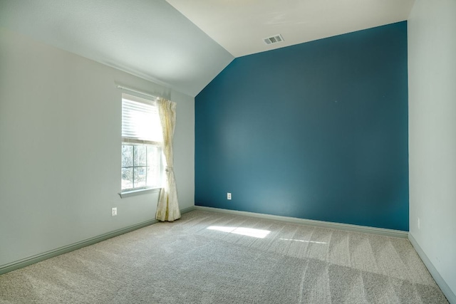 empty room with carpet, lofted ceiling, and baseboards