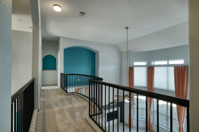 corridor featuring an upstairs landing, carpet floors, and vaulted ceiling