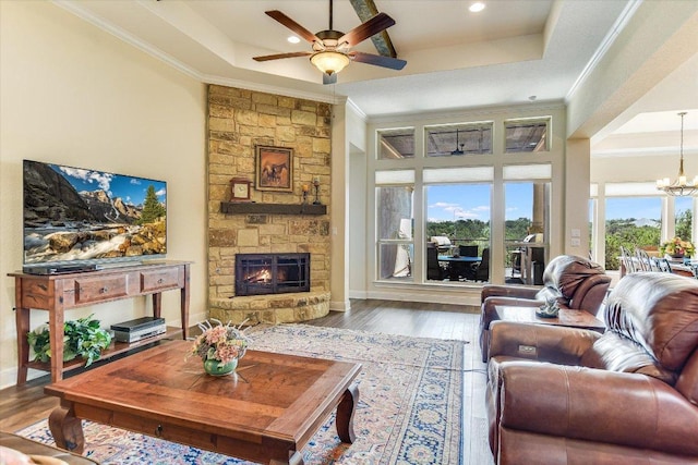 living area with crown molding, a ceiling fan, a fireplace, a chandelier, and recessed lighting