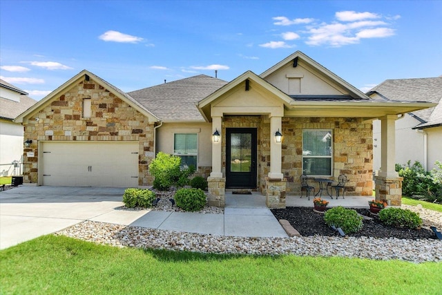 view of front of home with stone siding, a garage, stucco siding, driveway, and covered porch