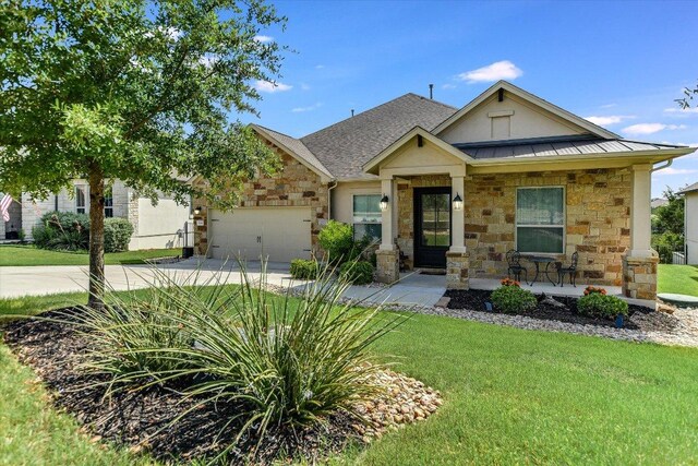 19440 Serenity Ln, Lago Vista, TX 78645 - craftsman-style house featuring stone siding, covered porch, driveway, a standing seam roof, and a front lawn