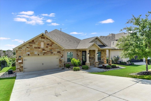 craftsman-style home featuring driveway, an attached garage, stone siding, and a front yard