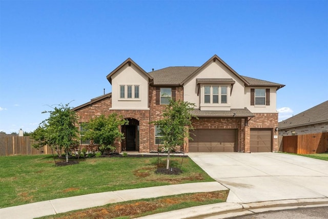 view of front of house with a garage, driveway, brick siding, and stucco siding