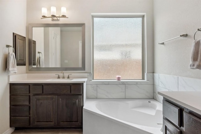 full bath with a garden tub and vanity