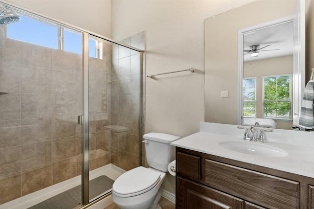 bathroom with a stall shower, a ceiling fan, toilet, and vanity