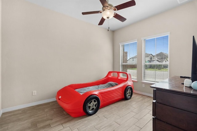 bedroom featuring light wood-style floors, baseboards, and a ceiling fan
