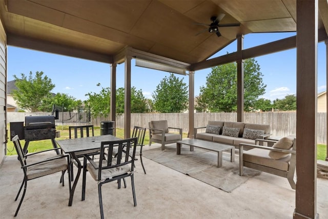 view of patio featuring outdoor lounge area, a ceiling fan, a trampoline, a fenced backyard, and outdoor dining area