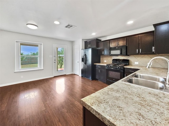 324 Pack Horse Dr, Bastrop, TX 78602 - kitchen featuring black appliances, light countertops, decorative backsplash, dark brown cabinetry, and dark wood-style floors