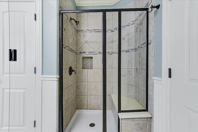 468 Monahans Dr, Georgetown, TX 78628 - bathroom with a shower stall, a decorative wall, crown molding, and wainscoting
