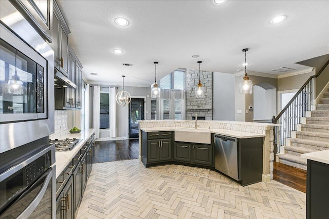 468 Monahans Dr, Georgetown, TX 78628 - kitchen featuring stainless steel appliances, light countertops, open floor plan, an island with sink, and crown molding