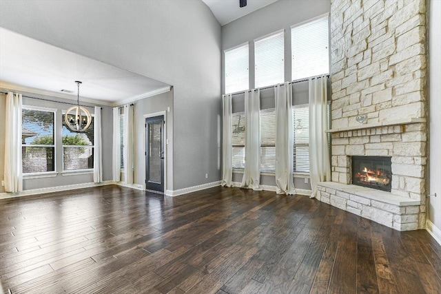 468 Monahans Dr, Georgetown, TX 78628 - unfurnished living room with a chandelier, a fireplace, a high ceiling, and wood finished floors