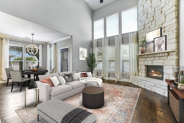 468 Monahans Dr, Georgetown, TX 78628 - living area with a chandelier, a towering ceiling, a stone fireplace, and hardwood / wood-style floors