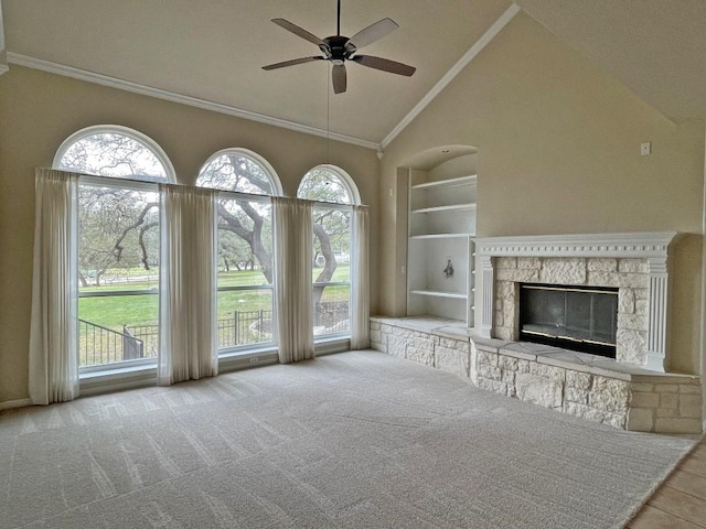 unfurnished living room featuring high vaulted ceiling, ceiling fan, healthy amount of natural light, built in shelves, and a fireplace