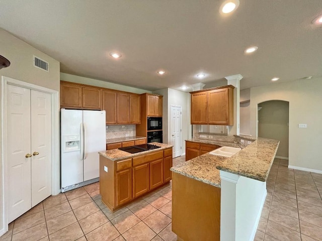 kitchen with black appliances, a sink, a peninsula, tasteful backsplash, and recessed lighting
