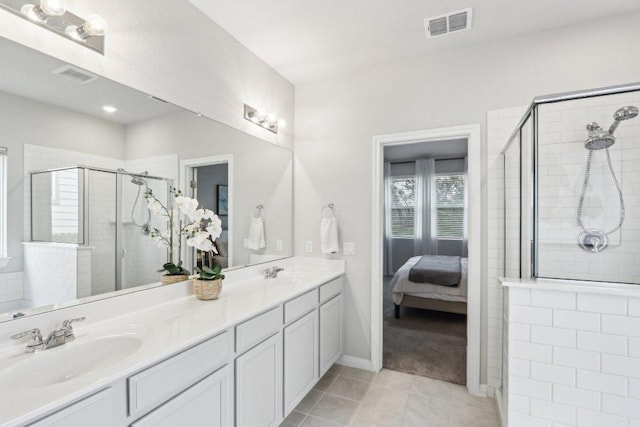 2024 Cantonata Dr, Leander, TX 78641 - full bath featuring a shower stall, double vanity, connected bathroom, and tile patterned floors