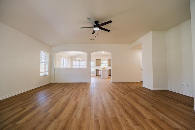 1420 Marsh Harbour Dr, Round Rock, TX 78664 - unfurnished living room with ceiling fan, light wood finished floors, arched walkways, baseboards, and lofted ceiling