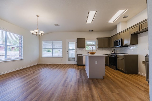 1420 Marsh Harbour Dr, Round Rock, TX 78664 - kitchen featuring stainless steel appliances, a kitchen island, a chandelier, dark wood finished floors, and vaulted ceiling