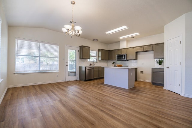 1420 Marsh Harbour Dr, Round Rock, TX 78664 - kitchen featuring appliances with stainless steel finishes, light countertops, tasteful backsplash, a chandelier, and wood finished floors