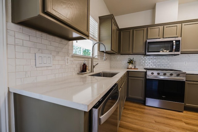 1420 Marsh Harbour Dr, Round Rock, TX 78664 - kitchen with stainless steel appliances, a sink, light wood-style floors, tasteful backsplash, and light stone countertops