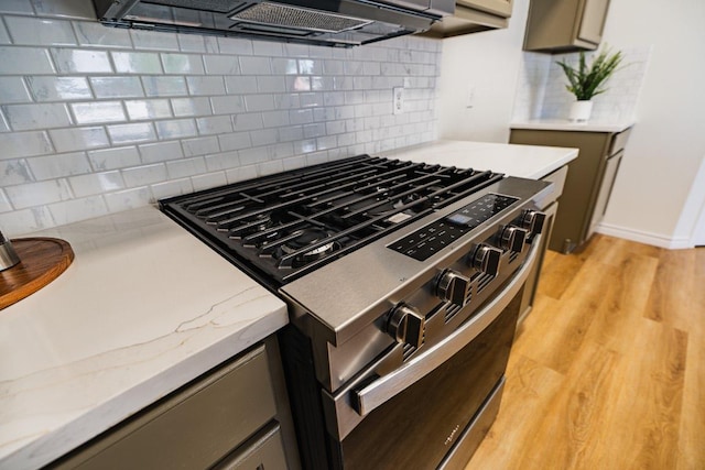 1420 Marsh Harbour Dr, Round Rock, TX 78664 - kitchen with stainless steel range with gas cooktop, decorative backsplash, light stone countertops, light wood-style flooring, and gray cabinets