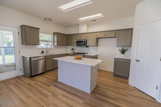 1420 Marsh Harbour Dr, Round Rock, TX 78664 - kitchen with stainless steel appliances, a sink, decorative backsplash, wood finished floors, and a kitchen island