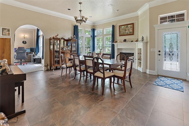 3424 S Old Bastrop Hwy, San Marcos, TX 78666 - dining room featuring arched walkways, ornamental molding, a chandelier, a textured ceiling, and a fireplace