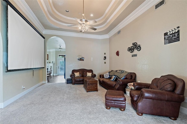3424 S Old Bastrop Hwy, San Marcos, TX 78666 - carpeted living area with crown molding, a tray ceiling, ceiling fan, arched walkways, and baseboards
