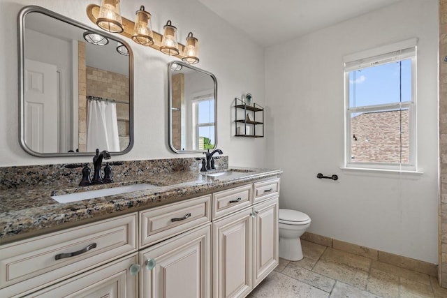 21016 Penny Royal Dr, Pflugerville, TX 78660 - bathroom with toilet, baseboards, double vanity, a shower with shower curtain, and stone tile floors