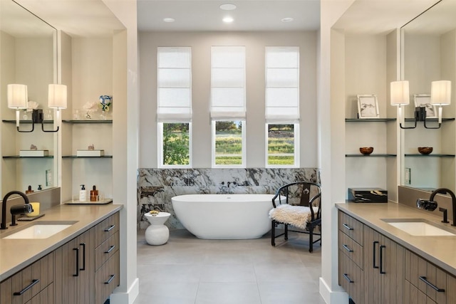 6404 Madrone Tree Ln, Austin, TX 78738 - bathroom with tile patterned floors, two vanities, tile walls, a soaking tub, and a wainscoted wall