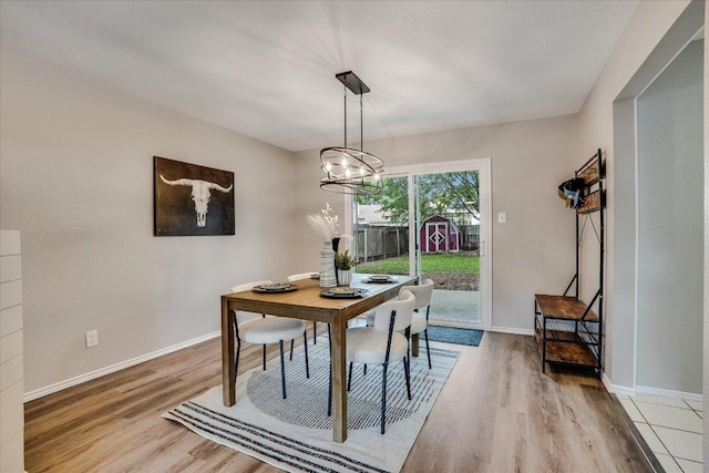 7605 Hawkeye Dr, Austin, TX 78749 - dining room featuring light wood-style floors, baseboards, and a chandelier