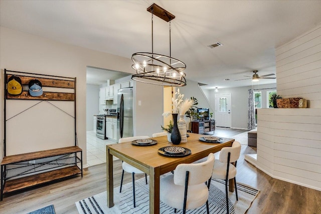 7605 Hawkeye Dr, Austin, TX 78749 - dining room featuring light wood finished floors, a chandelier, a ceiling fan, and baseboards