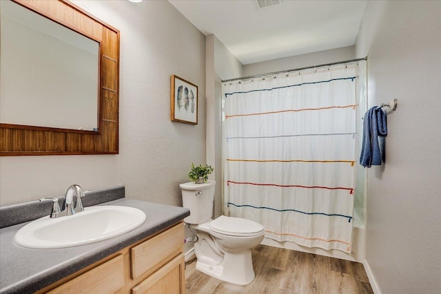 7605 Hawkeye Dr, Austin, TX 78749 - full bath featuring wood finished floors, toilet, vanity, shower / bath combo with shower curtain, and baseboards