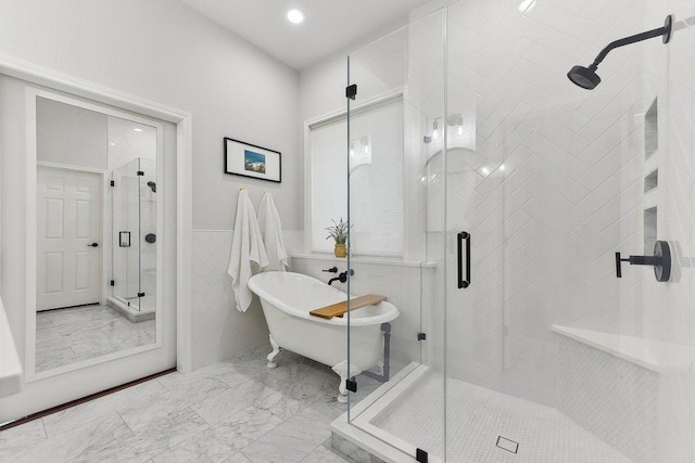 340 Palo Alto Way, Austin, TX 78732 - full bathroom with marble finish flooring, a stall shower, a freestanding bath, tile walls, and a wainscoted wall