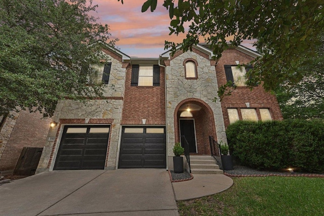 340 Palo Alto Way, Austin, TX 78732 - view of front of property with driveway, stone siding, an attached garage, and brick siding