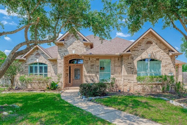 13403 Lakemeade Ct, Sugar Land, TX 77498 - french provincial home featuring a front lawn, brick siding, and roof with shingles