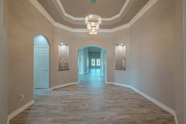 13403 Lakemeade Ct, Sugar Land, TX 77498 - hall featuring arched walkways, a chandelier, a tray ceiling, wood finished floors, and baseboards