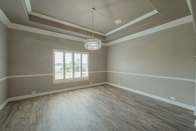 13403 Lakemeade Ct, Sugar Land, TX 77498 - spare room featuring a tray ceiling, a chandelier, wood finished floors, baseboards, and crown molding