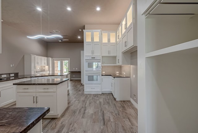 13403 Lakemeade Ct, Sugar Land, TX 77498 - kitchen featuring white double oven, light wood-style floors, recessed lighting, glass insert cabinets, and white cabinetry