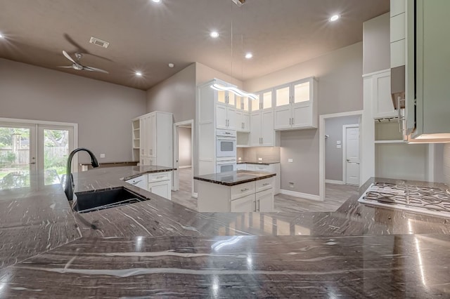 13403 Lakemeade Ct, Sugar Land, TX 77498 - kitchen with a sink, a high ceiling, dark stone countertops, recessed lighting, and a center island