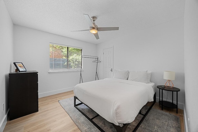 12001 Bittern Holw, Austin, TX 78758 - bedroom with light wood-style flooring, a textured ceiling, and a ceiling fan