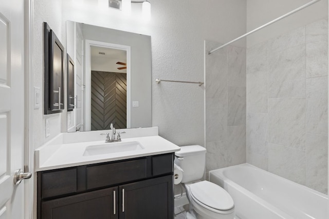 full bathroom featuring toilet, vanity, a textured wall, and shower / washtub combination