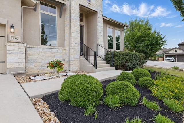 entrance to property featuring stone siding and stucco siding
