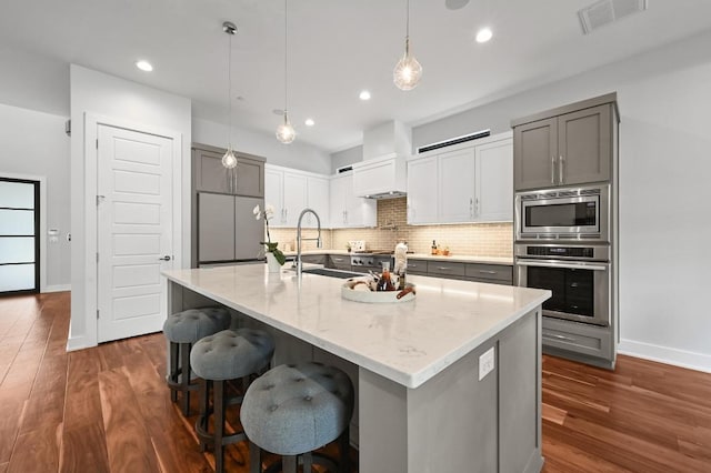 3102 Hunt Trl, Austin, TX 78757 - kitchen with built in appliances, a sink, decorative backsplash, baseboards, and dark wood-type flooring