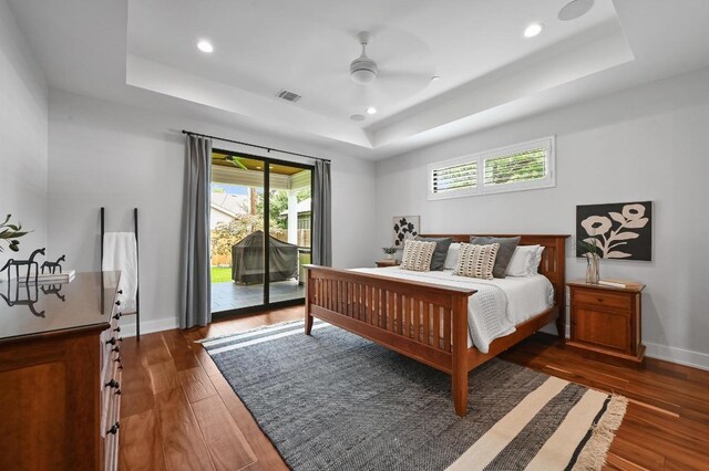 3102 Hunt Trl, Austin, TX 78757 - bedroom featuring a tray ceiling, access to exterior, multiple windows, dark wood-type flooring, and recessed lighting
