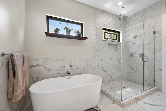3102 Hunt Trl, Austin, TX 78757 - bathroom with tile walls, a soaking tub, marble look tile flooring, a marble finish shower, and a wainscoted wall