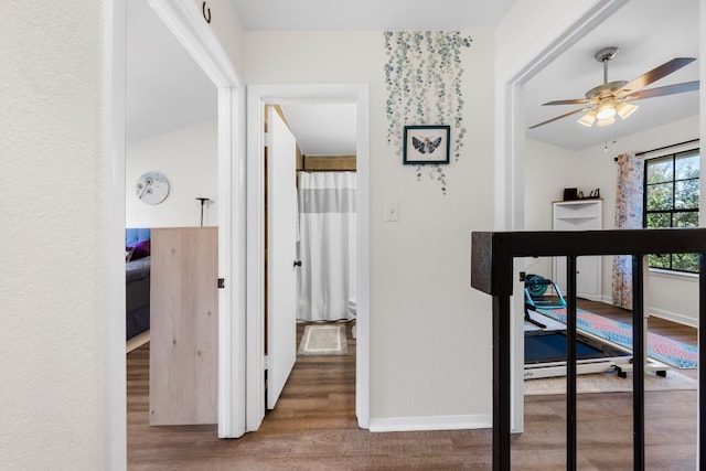 hallway with wood finished floors and baseboards