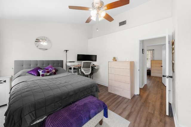 bedroom featuring vaulted ceiling, wood finished floors, ceiling fan, and baseboards